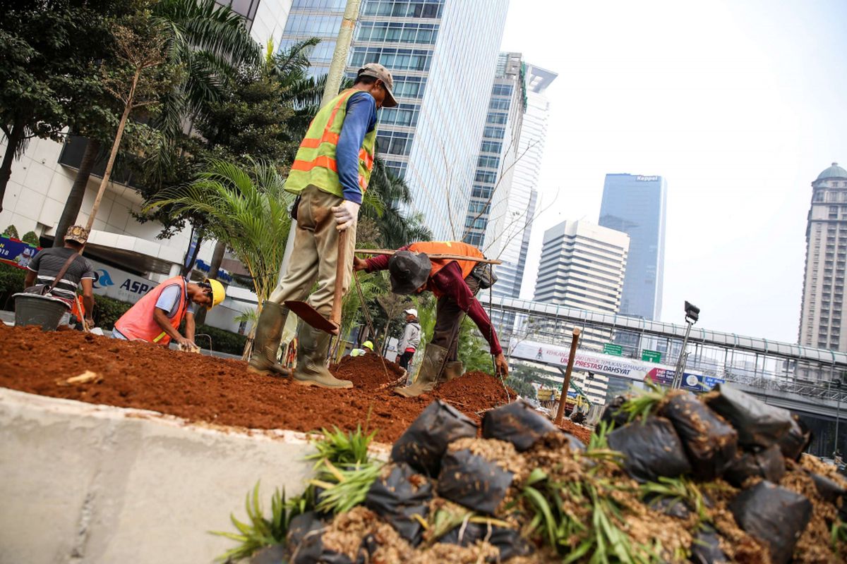 Pekerja menyelesaikan revitalisasi trotoar dan taman di kawasan jalan Sudirman, Jakarta Pusat, Kamis (19/7/2018). Penataan trotoar dan taman ditargetkan selesai pada akhir bulan Juli sebelum pelaksanaan Asian Games 2018.