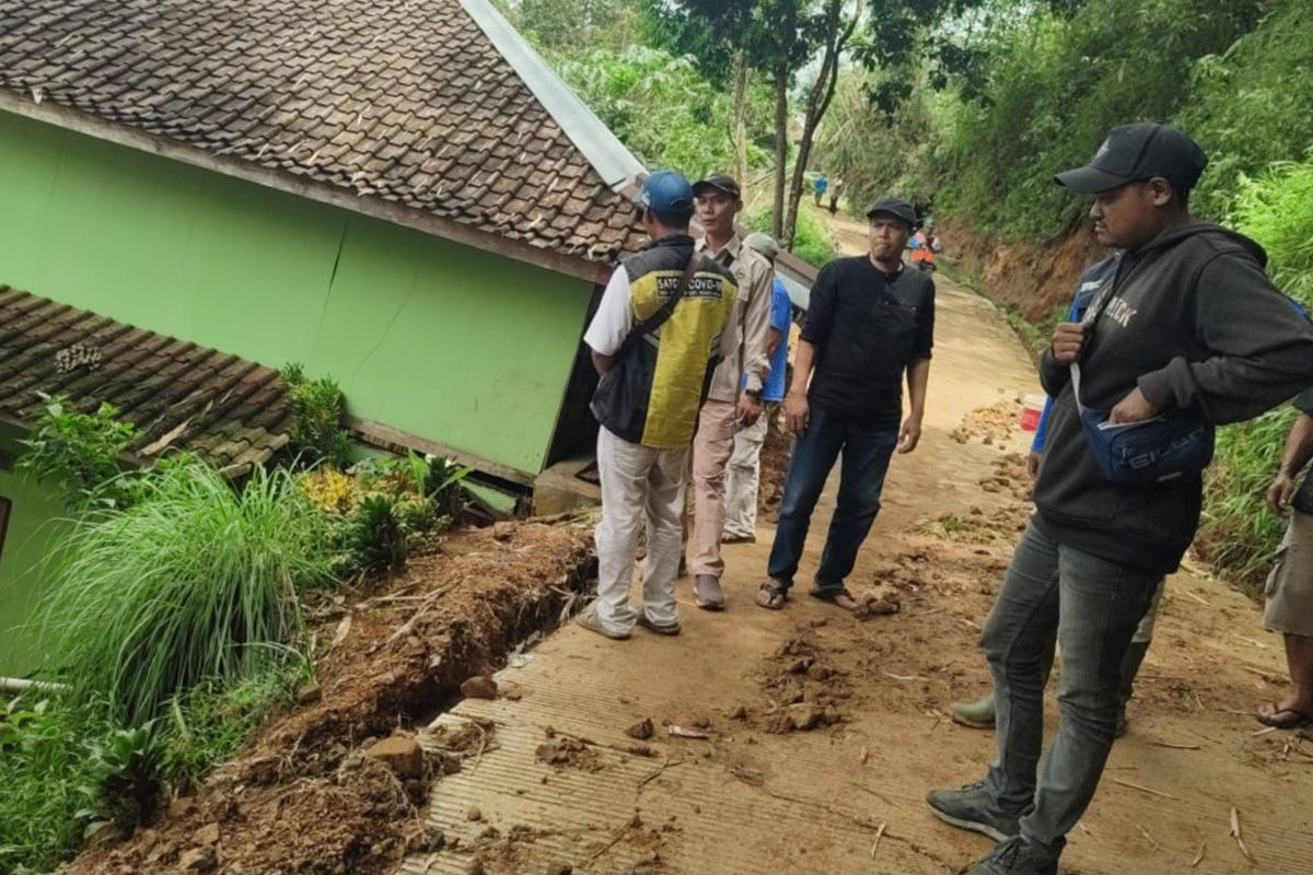Warga meninjau kondisi rumah terdampak pergeseran tanah di Kecamatan Kadupandak, Cianjur, Senin (25/11/2024)