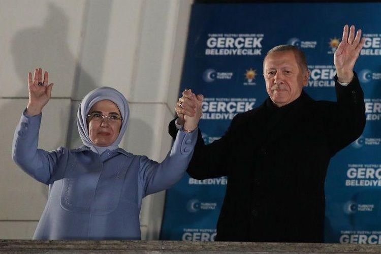 Presiden Turkiye, Recep Tayyip Erdogan (kanan), dan istrinya, Emine, memberi salam kepada para pendukungnya dalam pilkada di Ankara, 31 Maret 2024.