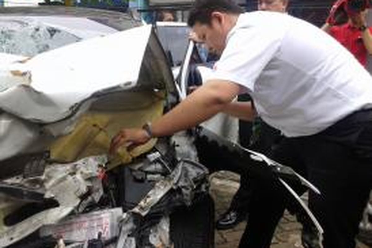 Tim Mitshubisi melakukan pemeriksaan fisik pada mobil Mitshubisi Outlander yang dikemudikan Christopher Daniel Sjafrie (23) saat kecelakaan, Senin,(26/1/2015).