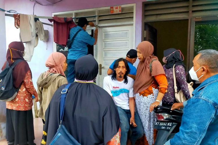 Petugas dan warga melakukan pembukaan pintu untuk menyelamatkan ketiga anak yang dikurung di dalam rumah.