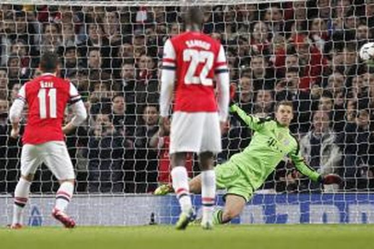 Kiper Bayern Muenchen, Manuel Neuer, berhasil menepis tendangan penalti gelandang Arsenal, Mesut Oezil, saat kedua tim bertemu pada leg pertama babak 16 besar Liga Champions di Stadion Emirates, Rabu (19/2/2014). 