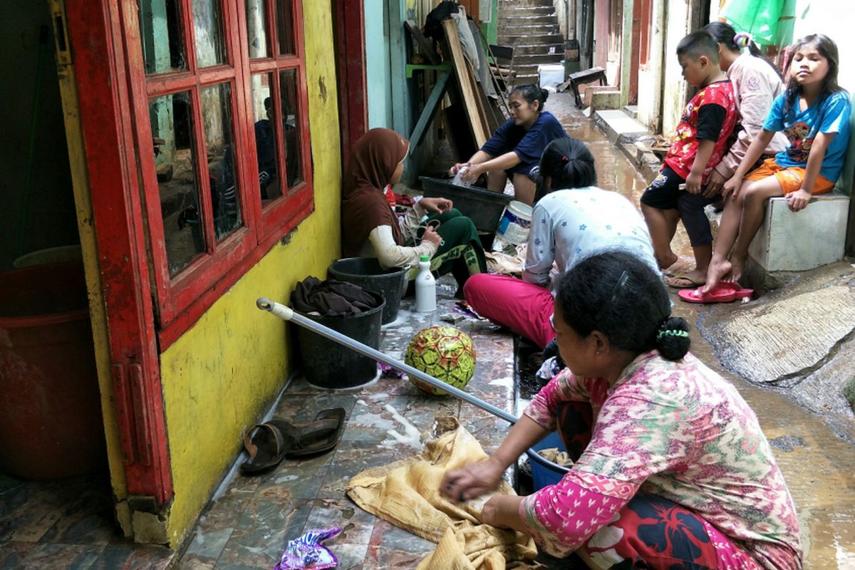 Warga RW 007 Kelurahan Rawajati, Pancoran, Jakarta Selatan, mulai mencuci pakaian mereka, Rabu (7/2/2018), yang terimbas banjir luapan Sungau Ciliwung sejak Senin (5/2/2018). Mereka mencuci di teras rumah yang sudah dibersihkan.