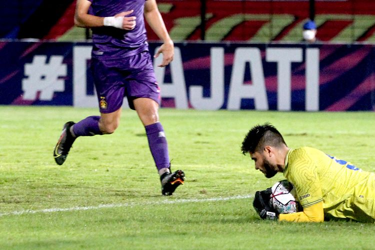 Penjaga gawang Arema FC Adilson Maringa menangkap bola tendangan dari Pemain Persik Kediri pada pertandingan pekan keduabelas Liga 1 2021-2022 yang berakhir dengan skor 2-3 di Stadion Sultan Agung Bantul, Jumat (19/11/2021) malam.