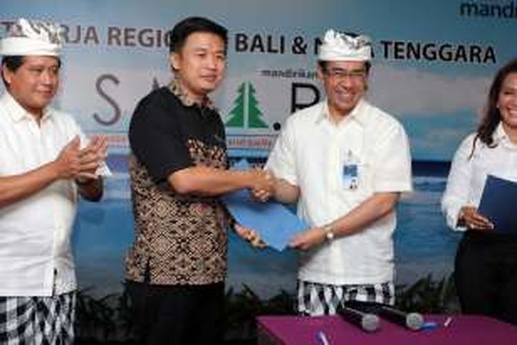 Regional CEO XI/Bali dan Nusa Tenggara Bank Mandiri Maswar Purnama (kedua kanan) usai meneken kerja sama disaksikan oleh Direktur Consumer Banking Hery Gunardi (kiri)