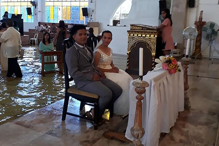 Foto yang diambil dari akun Facebook Bautista Banares Tere pada 11 Agustus 2018 memperliharkan Jobel Delos Angeles (24) dan tunangannya menggelar upacara pernikahan di dalam gereja yang terendam air di kota Hagonoy, sebelah utara Manila, Filipina.  
