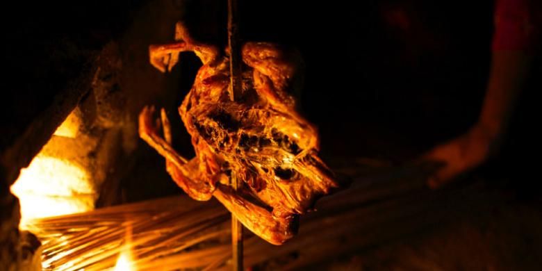 Ayam dibakar sebelum disuwir untuk Pecel Pitik di warung pesantogan Kemangi di Desa Kemiren, Kecamatan Glagah, Banyuwangi, Jawa Timur, Minggu (19/6/2016).