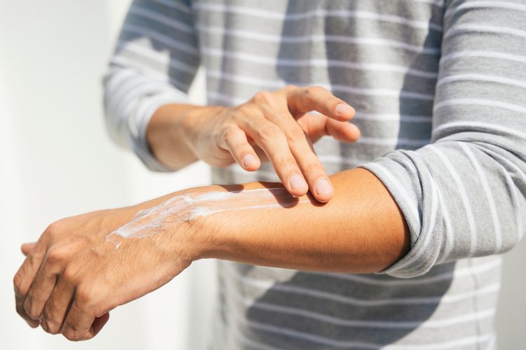 Mengoleskan sunscreen adalah salah satu cara mengatasi kulit belang di tangan.