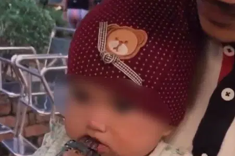 Tangkapan layar tayangan video yang memperlihatkan seorang bayi diberi vape oleh pria yang diduga sebagai orang tuanya.