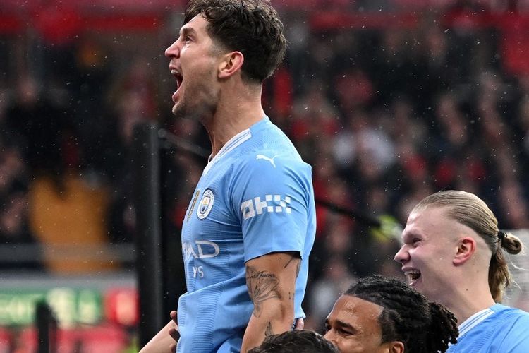 Pemain Man City, John Stones, merayakan gol pertama pada laga Liverpool vs Man City di ajang lanjutan Liga Inggris di Stadion Anfield, Minggu (10/3/2024).