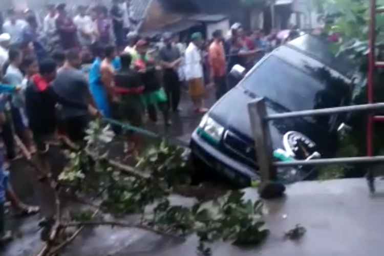 Proses evakuasi mobil yang terperosok akibat longsor.