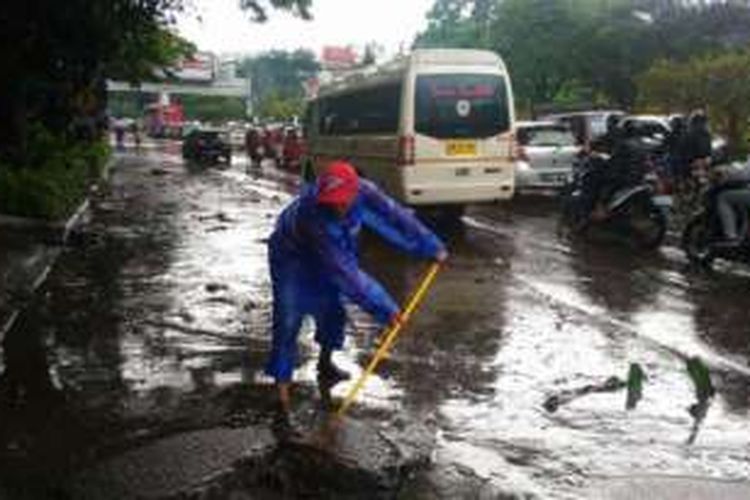 Petugas Dinas Bina Marga san Pengairan Kota Bandung membersihkan lumpur di pinggir Jalan dr Djundjunan, Kota Bandung, Senin (24/10/2016). 