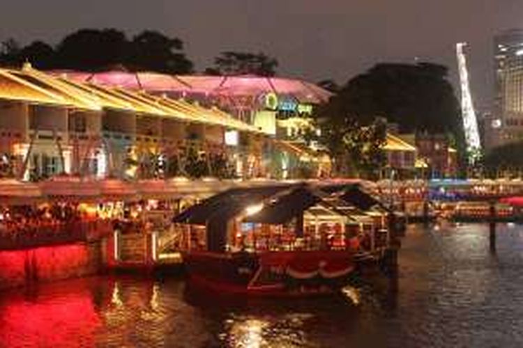 Nongkrong di pinggir sungai pada malam hari di Clarke Quay, Singapura.