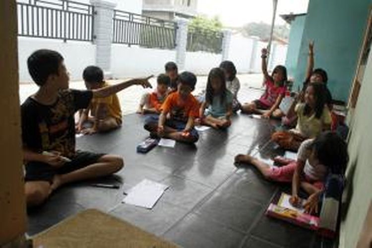 Sekelompok anak belajar bersama di pekarangan rumah karena sekolah diliburkan hingga batas waktu yang tidak ditentukan terkait kabut asap, di kawasan Kinibalu Pekanbaru, Rabu (16/9/2015).