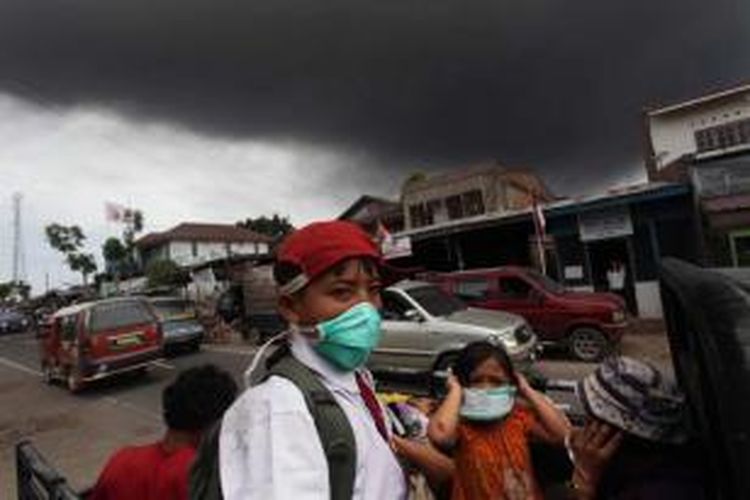 Warga berhamburan keluar rumah ketika abu vulkanik letusan Gunung Sinabung menutupi langit di Kabupaten Karo, Sumut, Selasa, 17 September 2013. Gunung kembali meletus pada pukul 12.03. Status gunung Siaga III.