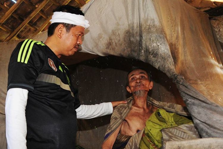 Bupati Purwakarta Dedi Mulyadi (berdiri, baju hitam) menemui warganya yang sudah berusia lanjut dan hidup sebatang kara dalam kemiskinan