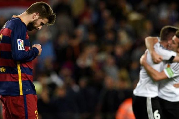 Gerard Pique tertunduk lesu seusai gawang Barcelona dijebol Valencia pada pertandingan La Liga di Camp Nou, Minggu (17/4/2016).