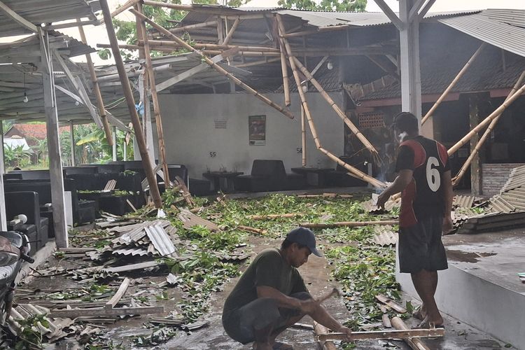 Warga membersihkan kafe yang rusak di Kecamatan Sukodono, Kabupaten Lumajang, usai diterjang angin puting beliung, Jumat (1/11/2024)