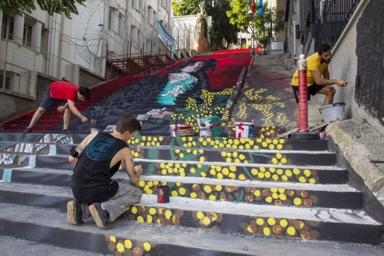 Mahasiswa dari Universitas Seni Rupa Mimar Sinan melukis di atas tangga jalanan di Istanbul, Turki, pada 5 Oktober 2020.