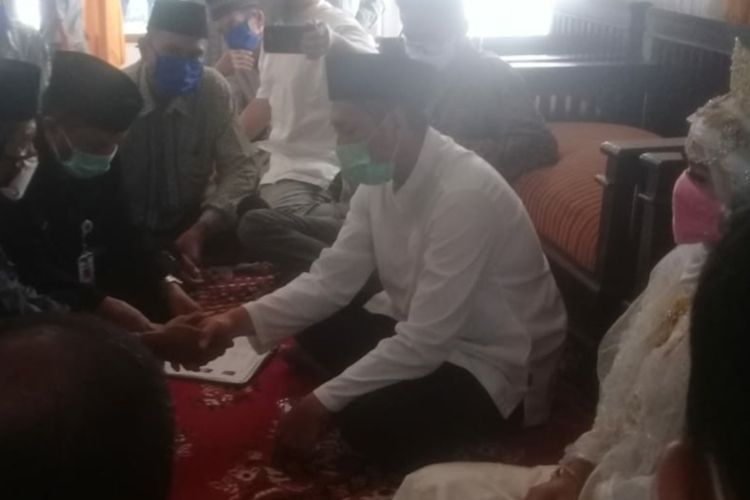 Pasangan pengantin di Banjarkolot, Kota Banjar, menggelar akan nikah dengan bermasker. Selain itu, mereka mencuci tangan dengan hand sanitizer sebelum dan setelah prosesi akad. 