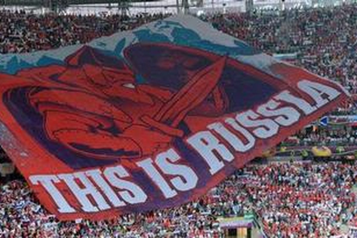 Suporter Rusia menggelar bendera raksasa di Stadion Nasional Warsawa, Selasa (12/6/2012), jelang laga melawan tuan rumah Polandia. 