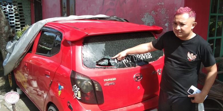 Zakaria menunjukkan jendela mobilnya yang menjadi sasaran tawuran remaja di Kota Magelang, Minggu (14/1/2024).