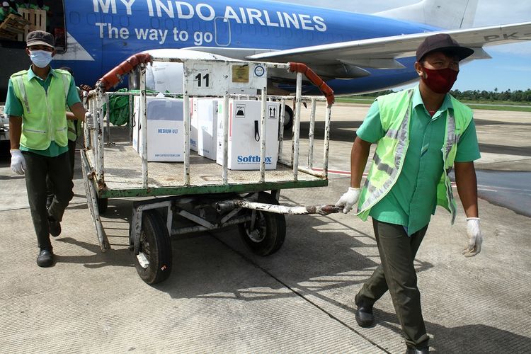 Petugas menarik kereta bermuatan sejumlah kotak berisi vaksin Pfizer sesaat setelah tiba di Bandara Supadio di Kabupaten Kubu Raya, Kalimantan Barat, Sabtu (2/10/2021). Sebanyak 453.960 vaksin Pfizer dikirim ke Pontianak (Kalimantan Barat), Berau (Kalimantan Utara), Samarinda (Kalimantan Timur), Palangka Raya (Kalimantan Tengah), Padang (Sumatera Barat), Palembang (Sumatra Selatan) dan Pangkalpinang (Bangka Belitung) untuk didistribusikan guna mendukung program pemerintah dalam percepatan vaksinasi COVID-19. ANTARA FOTO/Jessica Helena Wuysang/pras.