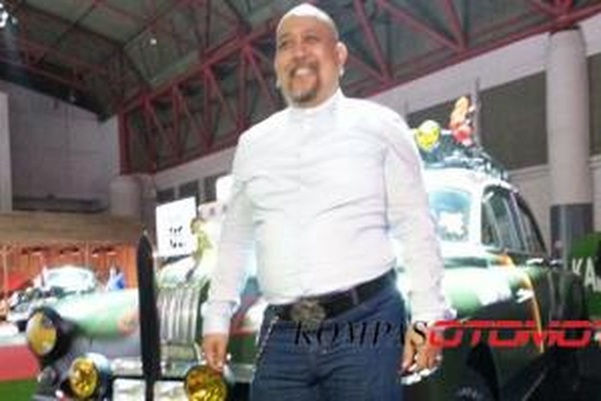 Indro Warkop berpose di depan mobil historis Warkop