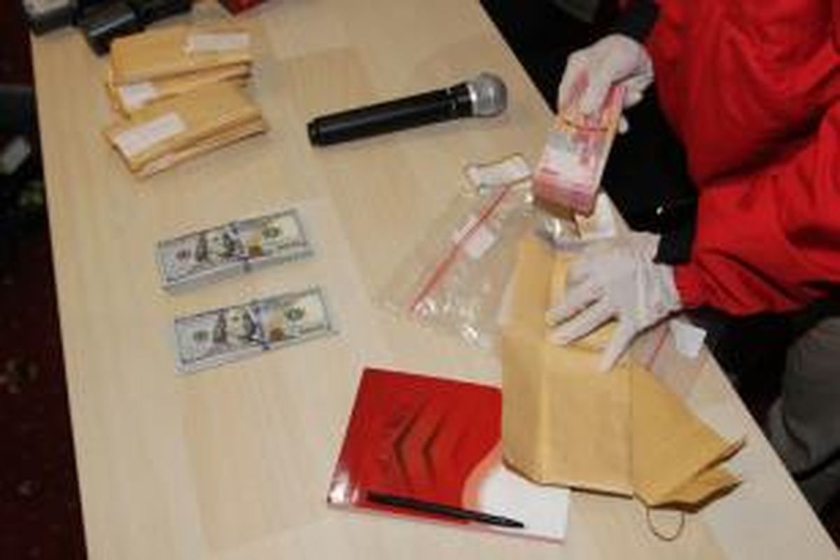 Penyidik Komisi Pemberantasan Korupsi (KPK) memperlihatkan barang bukti berupa mata uang dollar AS dan rupiah hasil operasi tangkap tangan (OTT) Anggota DPRD Banten, saat jumpa pers di kantor KPK, Jakarta Selatan, Rabu (2/12/2015).