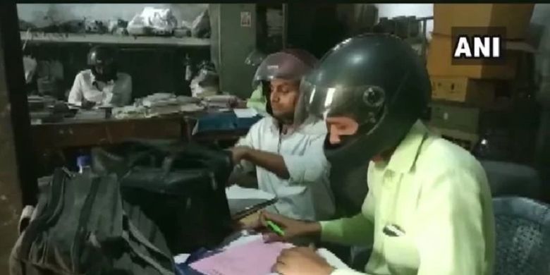 Dalam gambar yang beredar di media sosial, para karyawan kantor pemerintahan di Uttar Pradesh, India, menjadi perhatian setelah mengenakan helm di kantor.