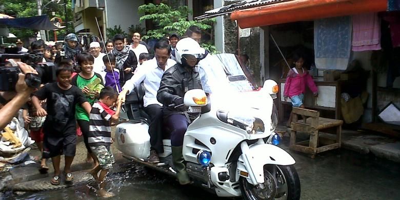 Gubernur DKI Jakarta Joko Widodo (berbaju putih) menerobos banjir Penjaringan, Jakarta Utara, Sabtu, (26/1/2013) dengan menggunakan motor gede Dinas Perhubungan DKI yang biasa ia gunakan sebagai voorijder. Di sana, ia tak hanya meninjau keadaan lokasi banjir, tapi juga memberikan bantuan berupa selimut, handuk, sembako, seragam, alat tulis, beras, dan sejumlah uang tunai.