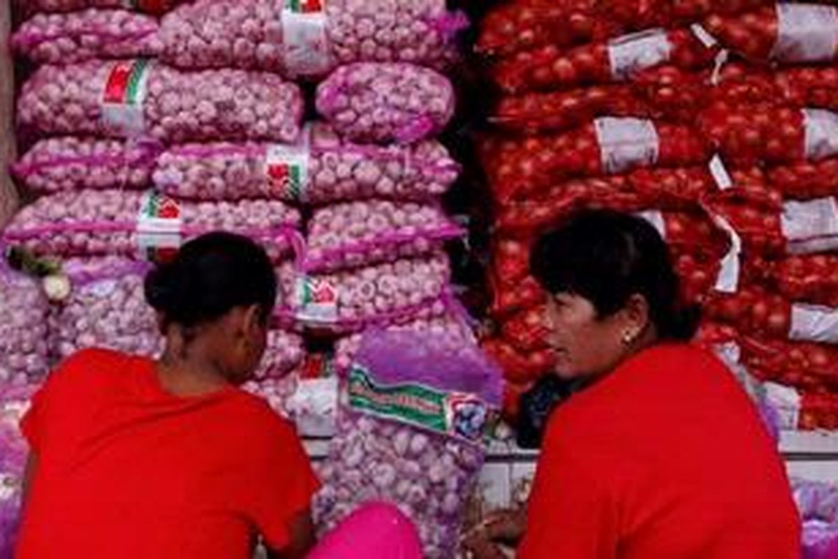 Buruh kupas bekerja mengupas Bawang Putih impor dari China di Pasar Induk Tanah Tinggi, Kota Tangerang, Banten, Sabtu (13/4/2013). Harga Bawang Putih dan Bawang Merah yang sempat meroket dan menjadi penyumbang inflasi bulan Maret kini berangsur-ansur normal. Bawang Putih di pasar tersebut dijual Rp. 15.000 per kilogram sedangkan Bawang Merah dijual Rp. 25.000 per kilogram.
