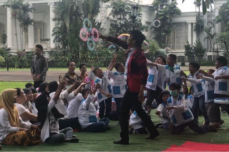 Presiden Joko Widodo, Ibu Negara Iriana dan anak-anak pengidap kanker saat menyaksikan atraksi gelembung udara di halaman Istana Presiden Bogor, Jumat (6/4/2018).