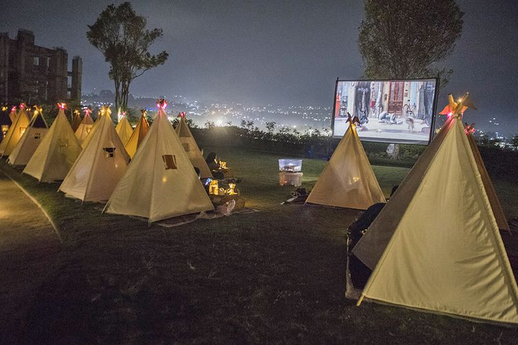 Pengunjung berada di dalam tenda saat menyaksikan film di bioskop outdoor 'Tenda di Bawah Bintang' di Parongpong, Kabupaten Bandung Barat, Jawa Barat, Rabu (4/11/2020). Bioskop outdoor Tenda di Bawah Bintang dihadirkan untuk memenuhi keinginan masyarakat yang ingin menyaksikan pertunjukan film layar lebar dengan tetap menerapkan protokol kesehatan dan social distancing.