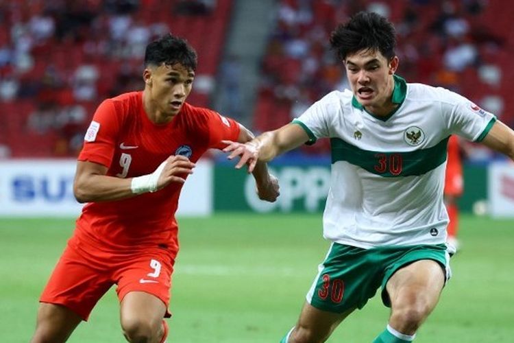 Pemain timnas Singapura, Ikhsan Fandi, berduel dengan bek Indonesia, Elkan Baggott, dalam laga leg pertama semifinal Piala AFF 2020. Laga timnas Singapura vs Indonesia digelar di National Stadium Singapura pada 22 Desember 2021.