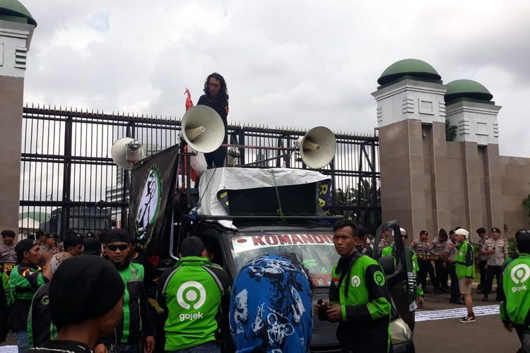 Massa pengemudi ojek online (ojol) menggelar aksi demonstrasi di depan gedung DPR/MPR, Senayan, Jakarta, Jumat (28/2/2020).