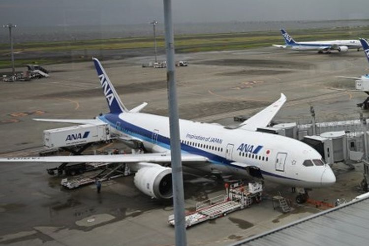 Pesawat penumpang All Nippon Airways (ANA) terlihat dari area pengamatan Bandara Haneda Tokyo pada 16 Agustus 2024 saat Topan Ampil meluncur menuju ibu kota Jepang. 