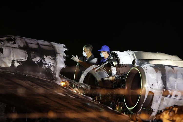 Petugas memeriksa bangkai pesawat Lionair yang jatuh dan terbakar di Bandara Internasional Ninoy Aquino, Manila, FIlipina, 29 Maret 2020. Kecelakaan pesawat yang mengangkut tenaga medis virus corona ini menewaskan 8 orang.