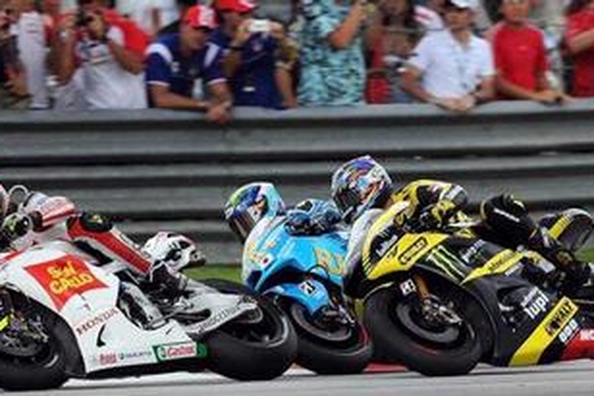 Marco Simoncelli (depan), bertarung dengan pebalap Rizla Suzuki, Alvaro Bautista (tengah), dan pebalap Yamaha Tech 3, Colin Edwards, pada GP Malaysia, Minggu (23/10/11). Ini sesaat sebelum kecelakaan di mana pada tikungan ini Simoncelli jatuh dan dilindas Edwards,