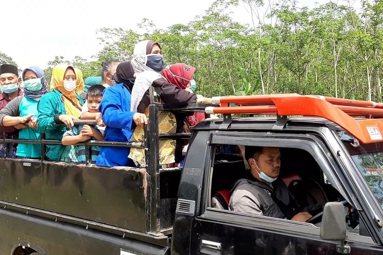 Para pengungsi Merapi saat menaiki mobil pickup untuk kembali ke rumahnya di Kalitengah Lor.