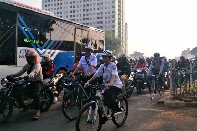 Kepala Dinas Kehutanan Suzi Marsitawati berbagi ruang dengan pengendara kendaraan bermotor di Jalan Pramuka, Jakarta Timur, pada hari pertama uji coba fase satu jalur sepeda, Jumat (20/9/2019).