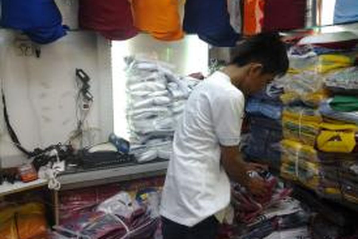 Eri, saat menjual berbagai kaos bola di Pasar Tanah Abang, Jakarta, Rabu (23/7/2014).