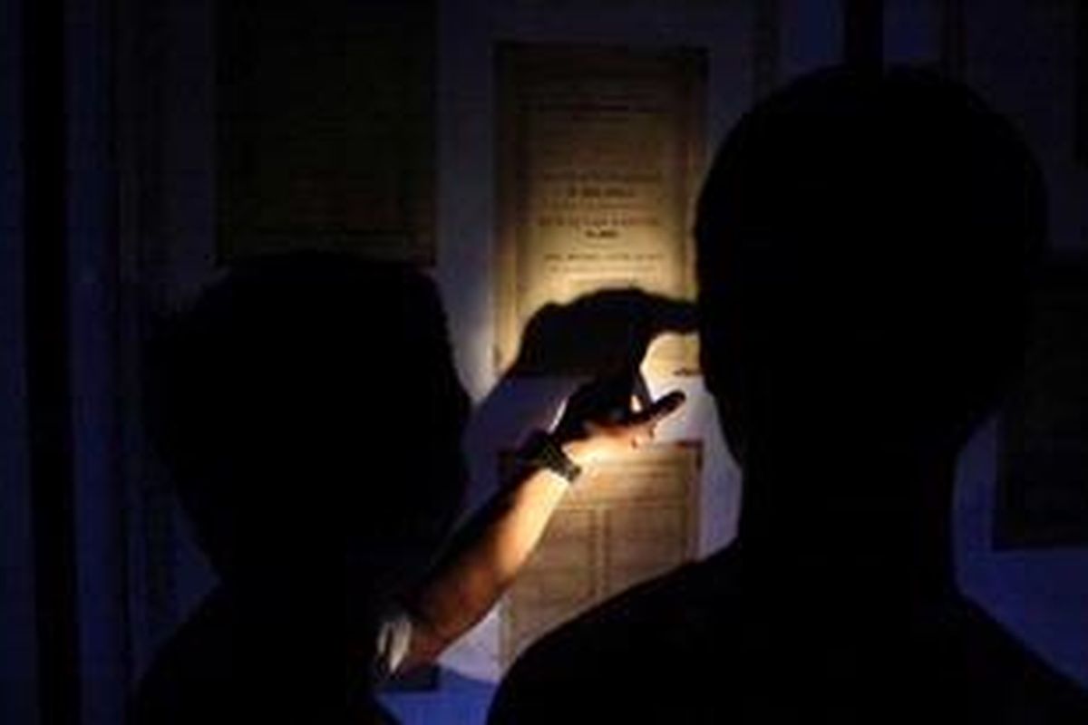 Berbekal senter, peserta wisata malam Kota Tua melihat peninggalan di tengah kegelapan Museum Mandiri.