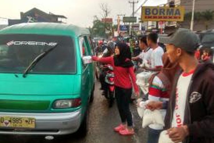 Laskar Jokowi-JK, membagikan 3.000 paket takjil gratis kepada pengendara sepeda motor, sopir dan penumpang angkutan umum  serta pengguna jalan KH. Wahid Hasyim, Katapang, Kabupaten Bandung, Jawa Barat, Sabtu (5/7/2014).