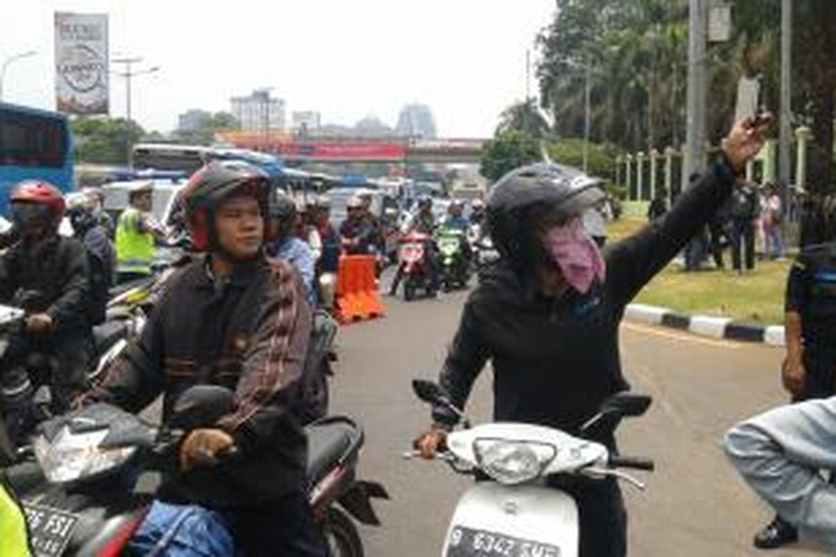 Pengendara sepeda motor di Jalan Gatot Subroto, berusaha mengabadikan moment dengan memotret iring-iringan kendaraan kepresidenan yang membawa Presiden Joko Widodo, Senin (20/10/2014).