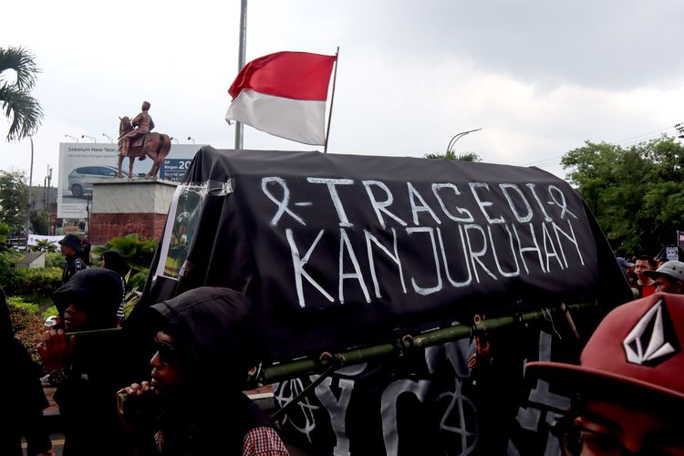 Suporter Arema, Aremania dan masyarakat membawa ornamen keranda saat melakukan aksi damai terkait Tragedi Kanjuruhan untuk menuntut keadilan yang dilaksanakan serentak di sejumlah titik Kota Malang, Minggu (27/11/2022) siang.