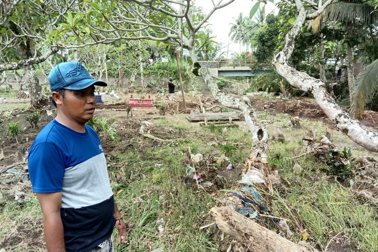 Warga menunjukkan kawasan makam yang rusak diterjang banjir di Banyuwangi.