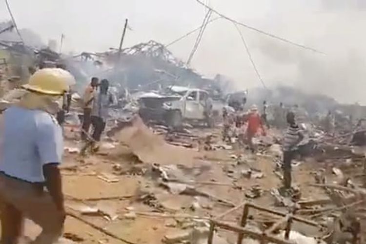 Orang-orang berada di sekitar lokasi ledakan truk pembawa bahan peledak yang meledak di Ghana barat pada Kamis (20/1/2022). 