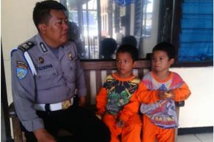 Seorang petugas polisi tengah menemani Nova dan Desta, dua bocah yang mengaku berasal dari Kota Semarang yang tersesat hingga ke Ungaran, Kabupaten Semarang.