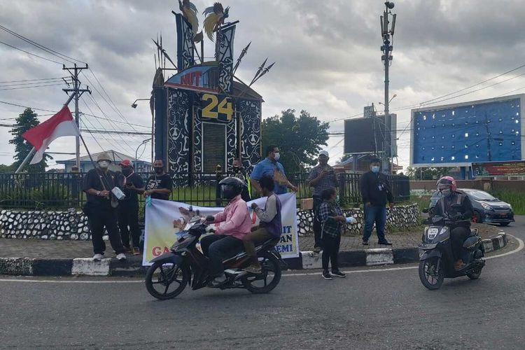 Sejumlah jurnalis Timika saat membagikan masker kepada pengguna jalan di Bundaran Timika Indah, Selasa (9/2/2021).